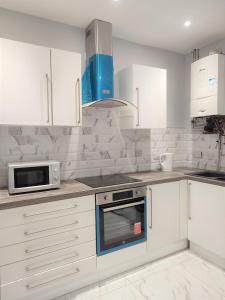 a kitchen with white cabinets and a microwave at havilahomes in Manchester