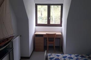 a small desk in a room with a window at Grand appartement 4/5 personnes in Bartrés