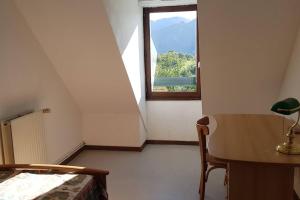 a bedroom with a window and a desk and a table at Grand appartement 4/5 personnes in Bartrés