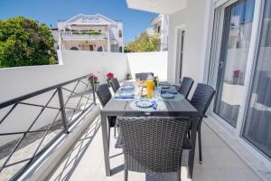 a dining table on a balcony with a view of the ocean at Fileo Family and Friends Living in Archangelos