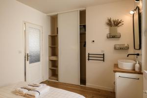 a white bathroom with a sink and a mirror at Appartement T2 - Vue imprenable sur la cathédrale in Quimper