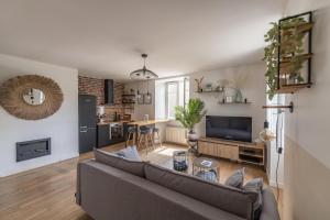 una sala de estar con un sofá y una mesa en Appartement T2 - Vue imprenable sur la cathédrale, en Quimper