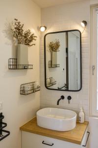 baño con lavabo blanco grande y espejo en Appartement T2 - Vue imprenable sur la cathédrale, en Quimper