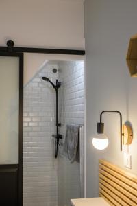 La salle de bains est pourvue d'une douche avec une porte en verre. dans l'établissement Appartement T2 - Vue imprenable sur la cathédrale, à Quimper