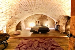 a bedroom with a bed in a stone room at Spa Gaalor***** - Jacuzzi & Sauna à Rouen in Rouen