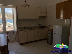a kitchen with a white refrigerator and a window at Magi - Pergola in Ponza