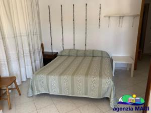 a bedroom with a bed with a green bedspread at Magi - Pergola in Ponza