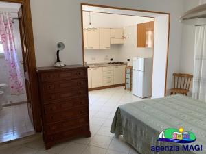 a kitchen with a bed and a dresser in a room at Magi - Pergola in Ponza