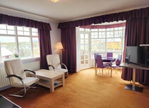 a living room with chairs and a table and windows at Kiljan Apartments & Rooms in Blönduós