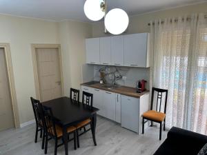 a kitchen and dining room with a table and chairs at holiday house in Durrës