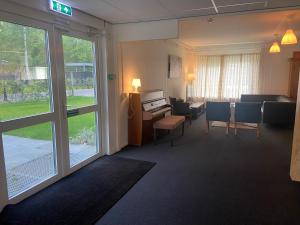 Habitación con escritorio y habitación con mesa y sillas. en Landgoed Leudal, en Haelen