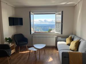 a living room with a couch and a large window at Casa Manuela in Castro Caldelas