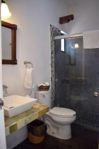 a bathroom with a toilet and a sink and a shower at Hotel Casa Alvarada in Comala