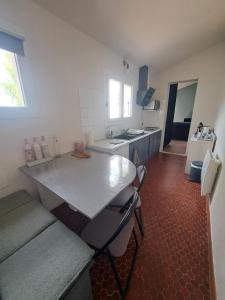 een keuken met een groot wit aanrecht in een kamer bij Studio avec jardin à 5 min du Parc Walibi in Roquefort