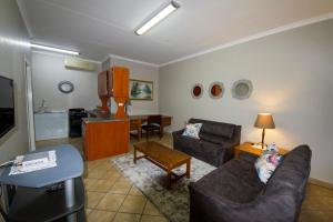 ein Wohnzimmer mit einem Sofa und einem Tisch in der Unterkunft @ Marula in Mokopane