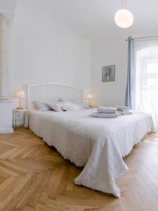 バンスカー・シュチャヴニツァにあるCYPRIAN apartmentの白いシーツが敷かれた大きなベッドのある白い寝室