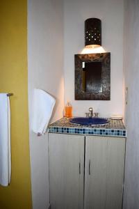La salle de bains est pourvue d'un lavabo et d'un miroir. dans l'établissement Hotel Casa Alvarada, à Comala