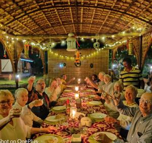 a group of people sitting at a long table at Emerald Isle in Alleppey