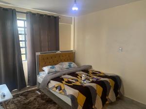a bedroom with a bed and a window at gold-apartment-and-luxury-home in Nairobi