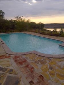 a large swimming pool with a view of the water at Von Bach Dam Resort in Okahandja
