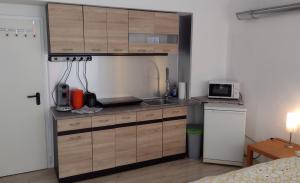 uma pequena cozinha com um lavatório e um micro-ondas em Kleines gemütliches Apartment in zentraler Lage em Prien am Chiemsee