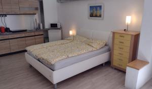 um pequeno quarto com uma cama e uma cómoda em Kleines gemütliches Apartment in zentraler Lage em Prien am Chiemsee