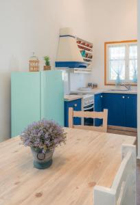 a kitchen with a wooden table with a blue refrigerator at Houses at Chrisopigi Sifnos in Chrisopigi
