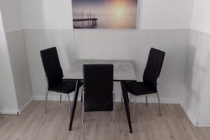 uma mesa e quatro cadeiras num quarto em Kleines gemütliches Apartment in zentraler Lage em Prien am Chiemsee