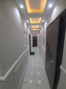 a hallway with white walls and a ceiling with lights at استديو in 6th Of October