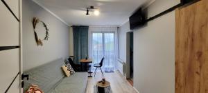 a living room with a bed and a window at Studio 2-pokojowe z balkonem z widokiem na góry in Międzybrodzie Żywieckie
