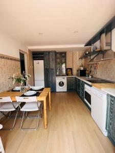 Una cocina con una mesa de madera y un comedor. en VILLA HUETOR , Piscina y barbacoa privada, en Huétor Vega