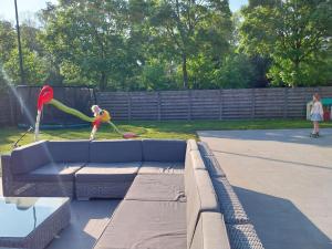 a child playing with a mop and a couch at Het vogelnestje in Ichtegem
