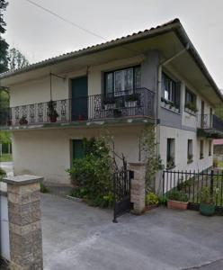 a white house with a balcony and a driveway at Erletxe Aterpea in Lezo