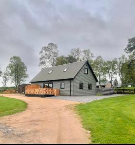a large gray barn with a driveway in front of it at Birchwood View in Aboyne
