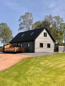 a large white barn with a black roof at Birchwood View in Aboyne