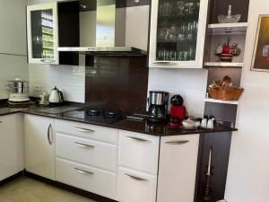 une cuisine avec des armoires blanches et un comptoir noir dans l'établissement Villa Liliana, à Sainte-Rose