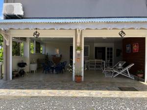 une maison avec un patio avec des chaises et des tables dans l'établissement Villa Liliana, à Sainte-Rose