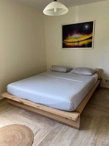 1 cama en un dormitorio con marco de madera en Villa Liliana, en Sainte-Rose