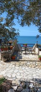 a stone patio with a picnic table and the ocean at Apartments Antigona Old Town in Ulcinj