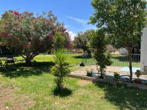 einen Garten mit Bäumen, einem Tisch und einem Zaun in der Unterkunft VILLA HUETOR , Magnifico chalet con piscina privada in Huétor Vega