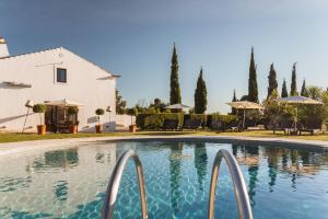 a swimming pool in front of a white building at Imani Country House in Évora
