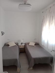 2 camas individuais num quarto com uma janela em Siorica Beach em Matalascañas