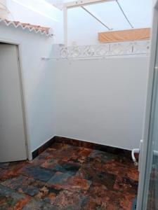 um quarto com uma parede branca e piso em azulejo em Siorica Beach em Matalascañas