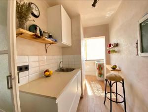 eine kleine Küche mit einer Spüle und einer Theke in der Unterkunft Junto al casco antiguo con terraza in Sevilla