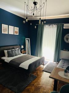 um quarto com uma cama e uma parede azul em Bulevard Apartments em Satu Mare