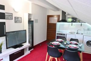 a kitchen with a table and chairs and a television at Discovery Apartment Bansko in Bansko