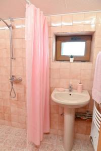 a bathroom with a pink shower curtain and a sink at Discovery Apartment Bansko in Bansko