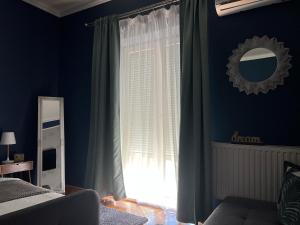 um quarto com paredes azuis e uma janela com cortinas em Bulevard Apartments em Satu Mare