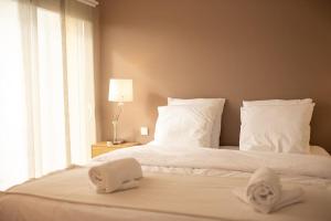 ein Schlafzimmer mit einem Bett mit weißen Laken und Kissen in der Unterkunft Villa Hibiscus à 10 min de l'océan in Saubion + 27 Fotos