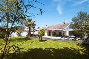 ein weißes Haus mit Garten in der Unterkunft Villa Hibiscus à 10 min de l'océan in Saubion